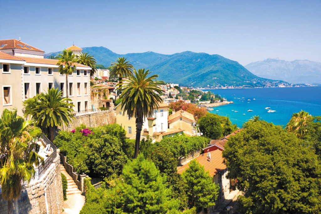 Radreise Westbalkan Albanien Montenegro - Blick von oben auf smaragdgrünes Meer und kleinen Yachten