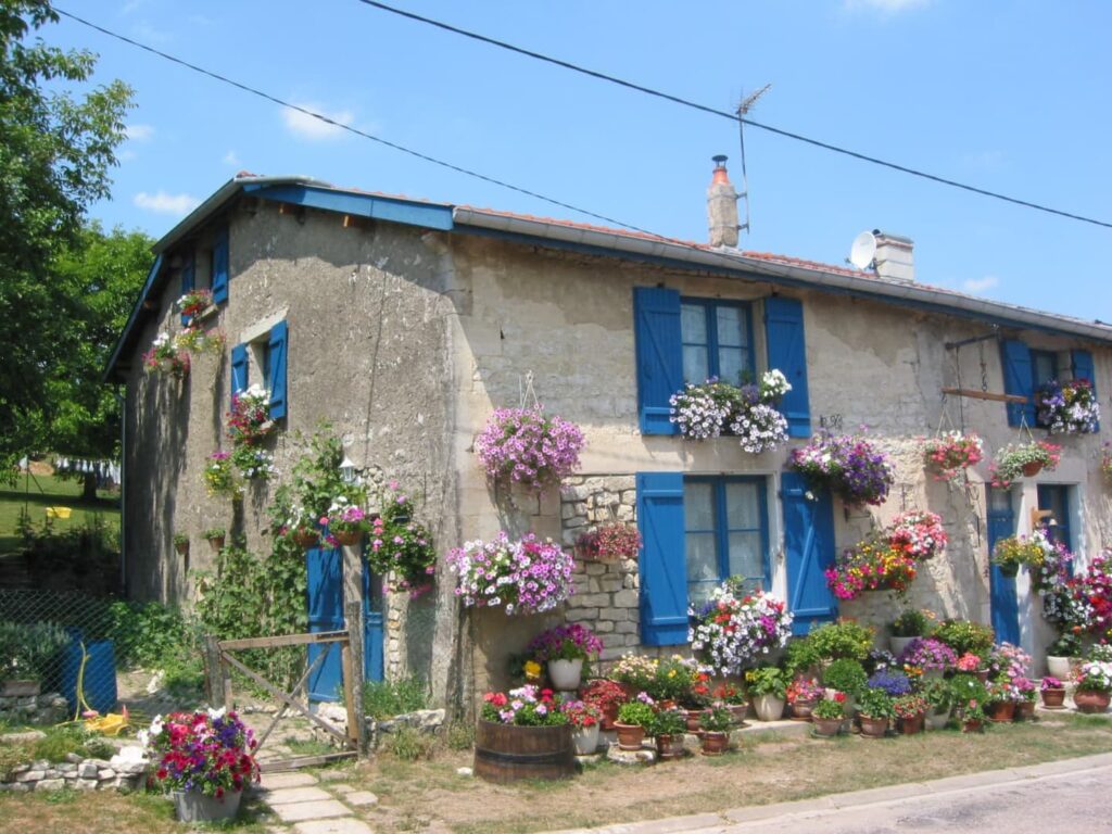 Rad und Schiffsreise von Paris nach Brügge - altes Haus mit bunten Blumen bestückt
