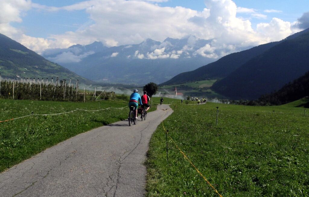 Radreise Deutschland Österreich Italien Via Claudia Augusta, Launer-Radgruppe von hinten einen befestigten Feldweg eines Alpentales befahrend