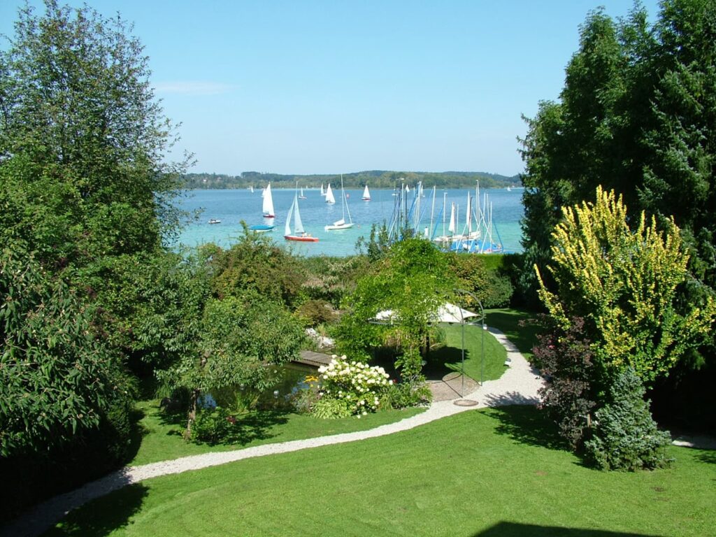 Radreise Deutschland Bayern Alpenrand, Blick von einem Seegrundstück über den Wörthsee mit Segelschiffen