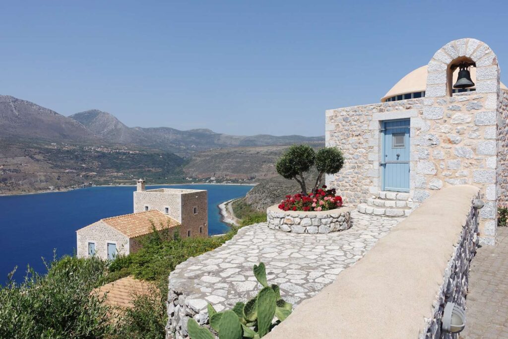 Radreise Griechenland Peloponnes - Wohnhaus mit Glocke oberhalb des Meeres am Hang