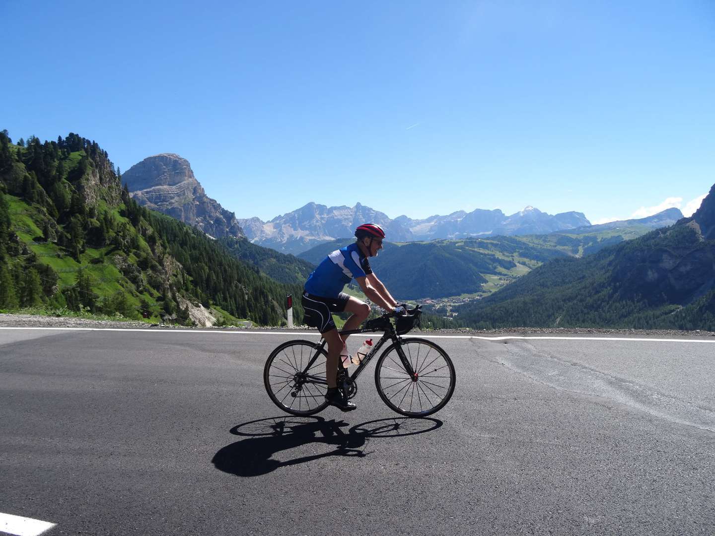 Rennradreise Italien Südtirol Venetien - Blick auf Bergmassiv - Rennradfahrer auf Passstraße in den Dolomiten