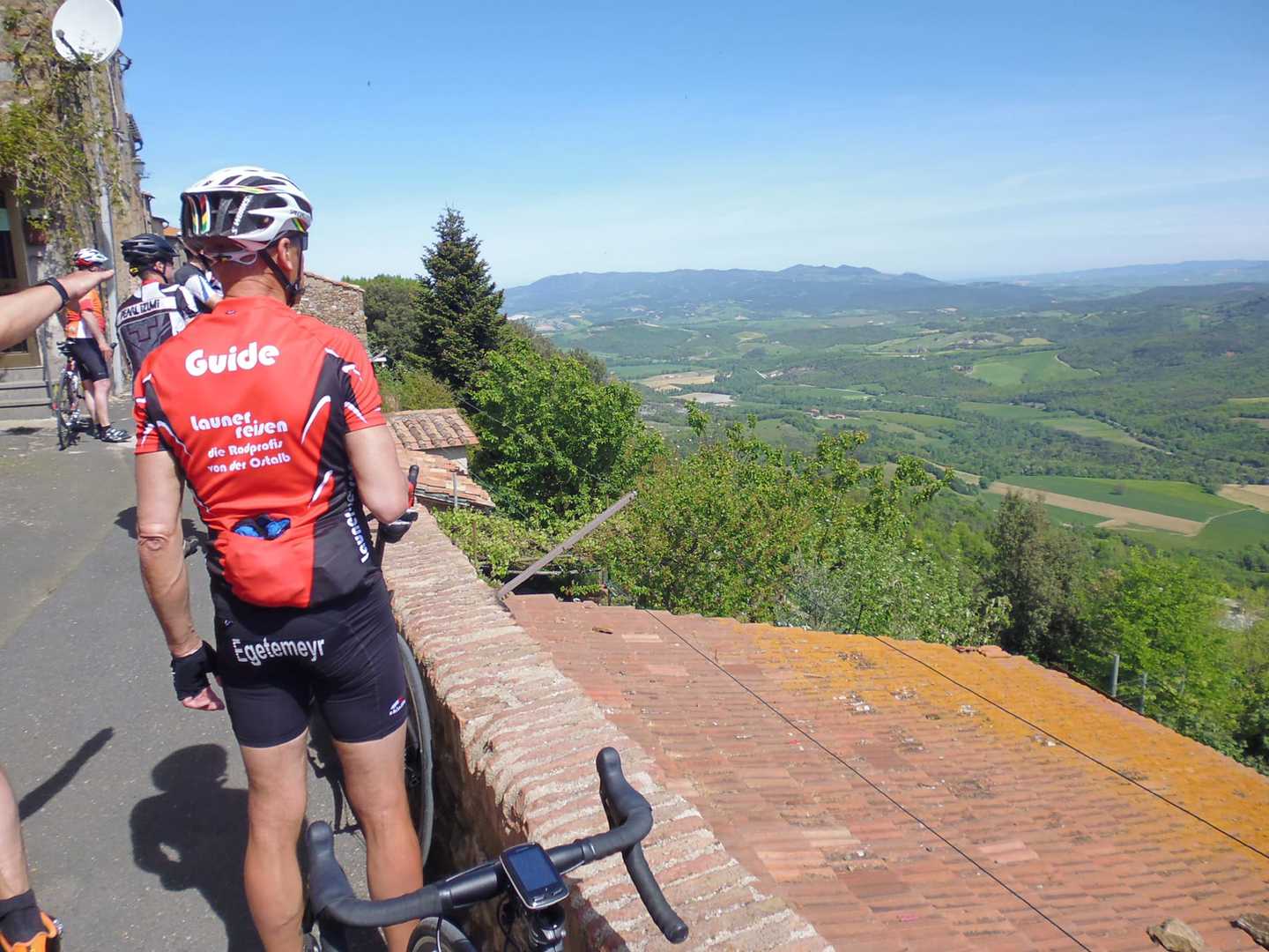 Rennradreise Italien Toskana Küste, Launer-Rennradgruppe mit Blick über die Landschaft der Toskana von Castagneto Caducci aus
