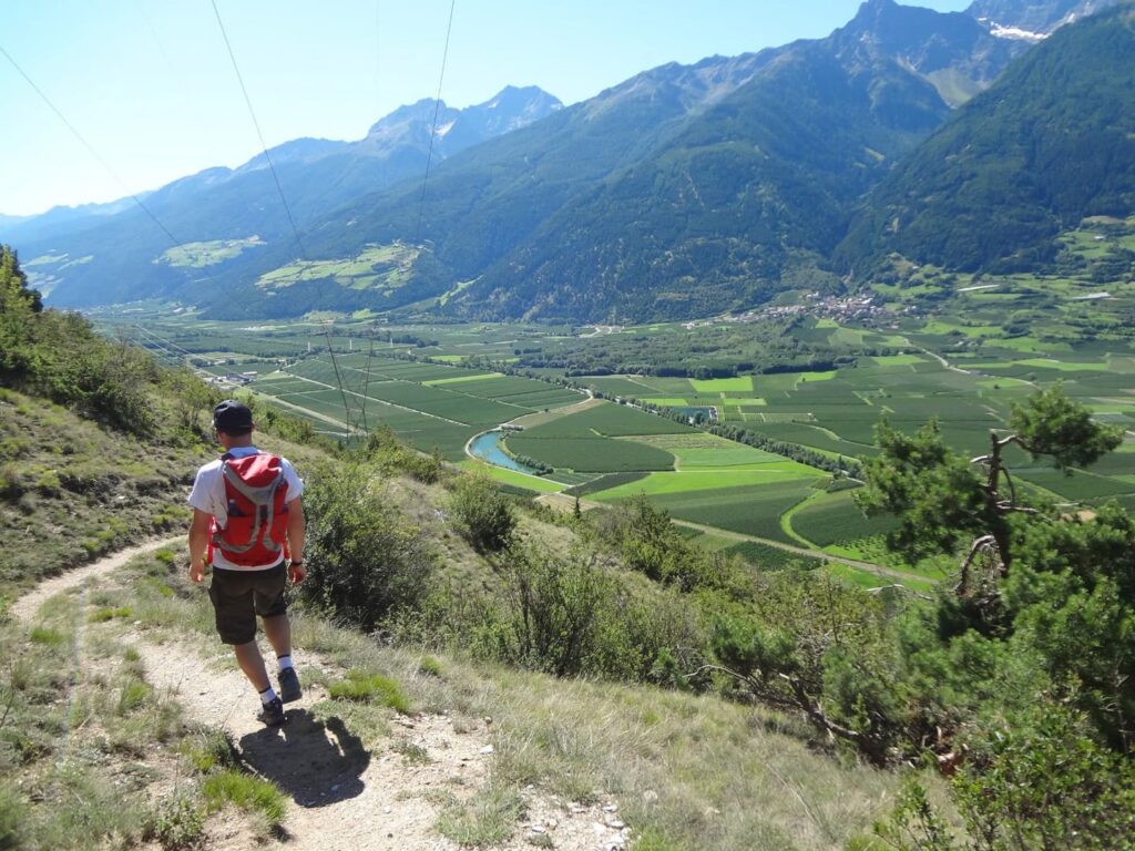 Wanderreise Deutschland Italien Garmisch Meran Wanderer auf Wanderweg bergab im Vinschgau