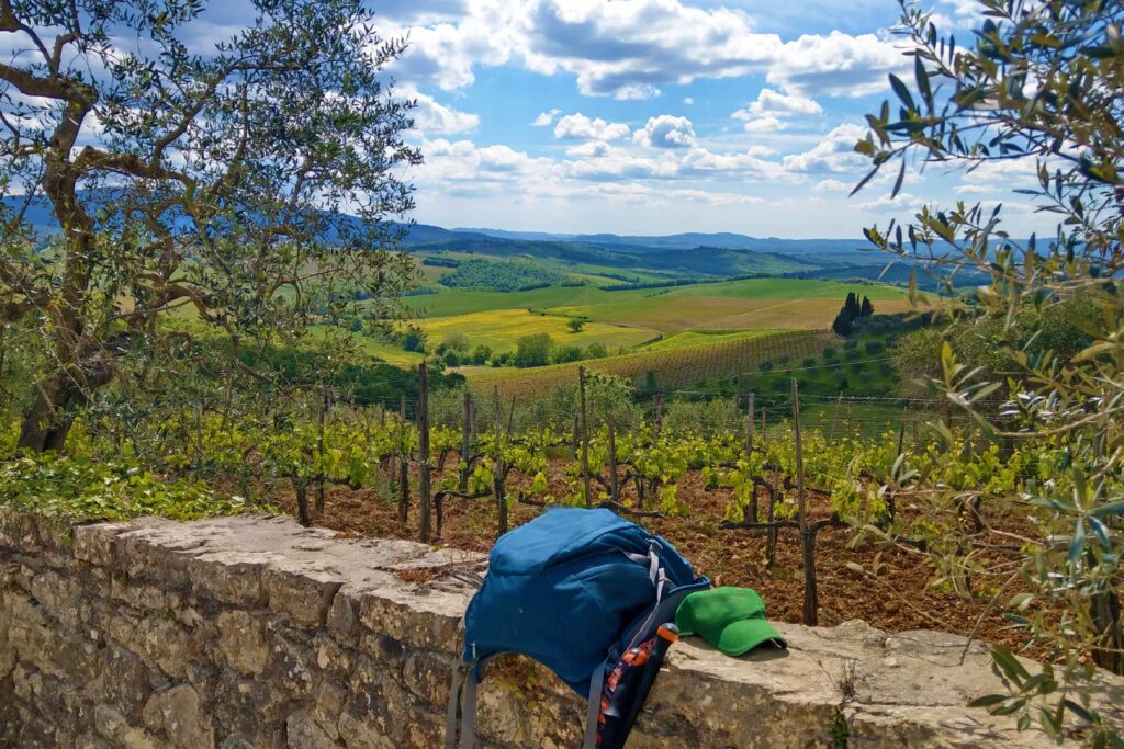 Wanderreise Italien Toskana - Rucksack auf Mauer mit wunderschöner Aussicht
